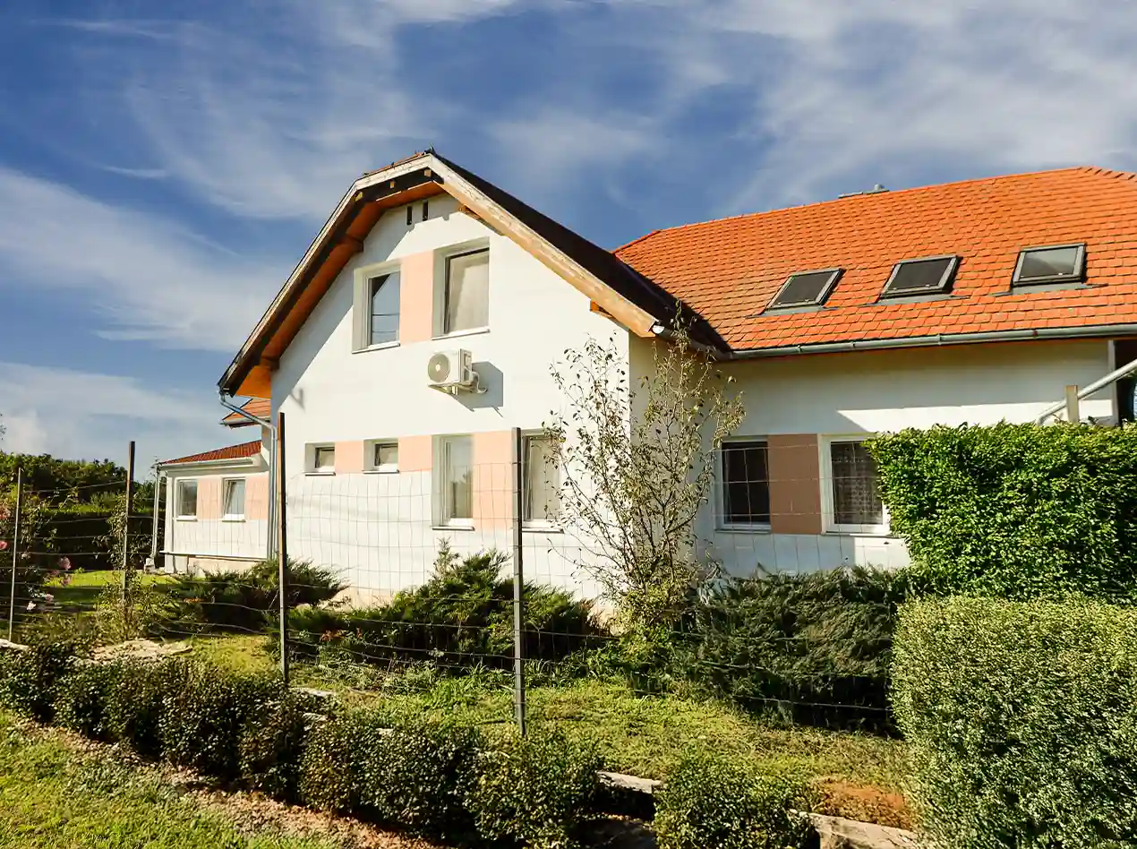 Außenansicht des Anna Gästehauses mit gepflegtem Garten und heller, ordentlicher Umgebung.