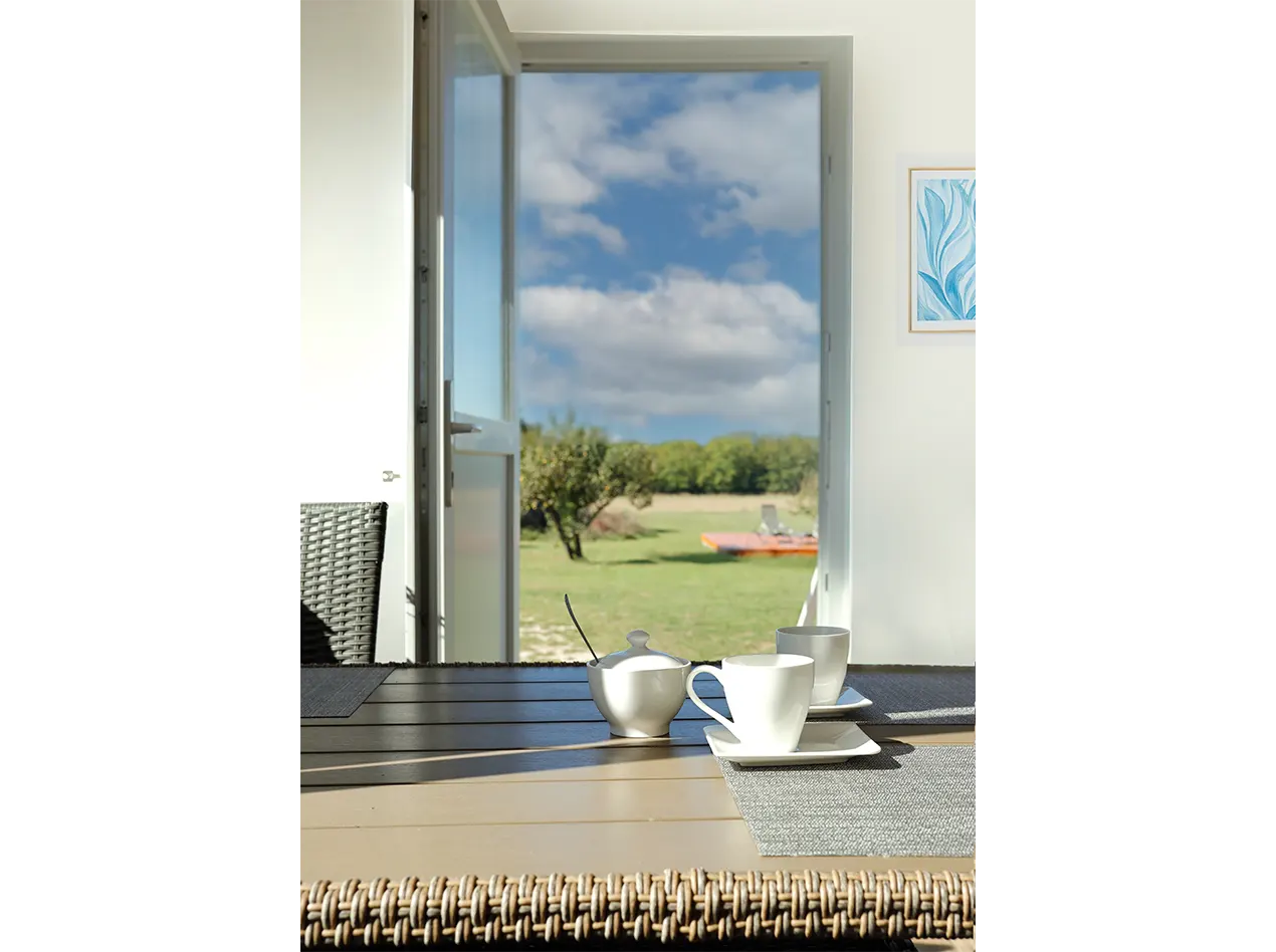 Kaffeetassen auf dem Tisch, mit offener Terrassentür und ruhigem Blick in den Garten im Anna Gästehaus.